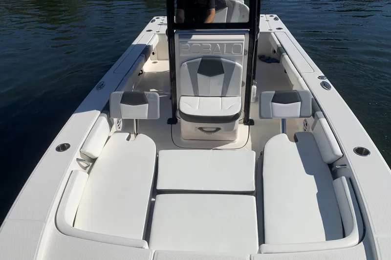 Slide: The Image of 2022 Robalo 246 Cayman boat interior with white seating and console on water. - 36