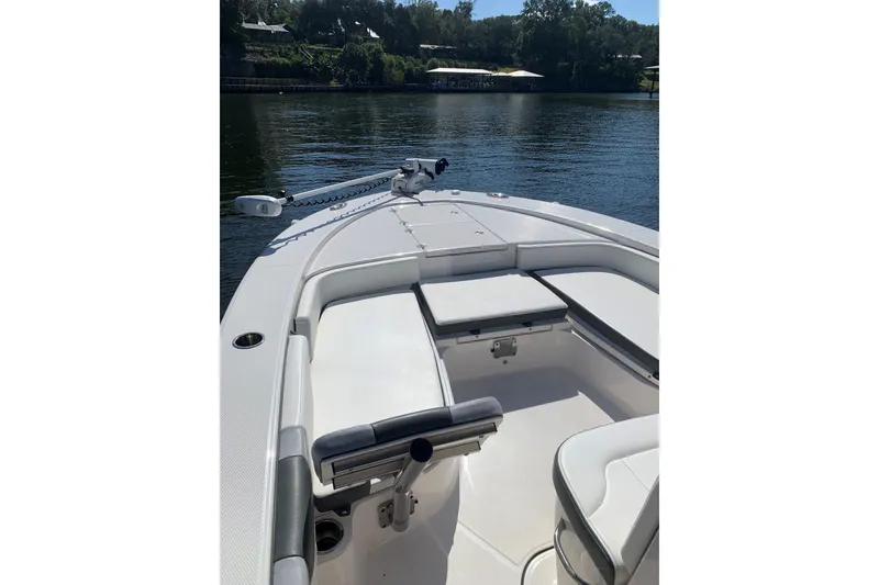 Slide: The Image of 2022 Robalo 246 Cayman boat interior with seating, on a calm lake. - 37