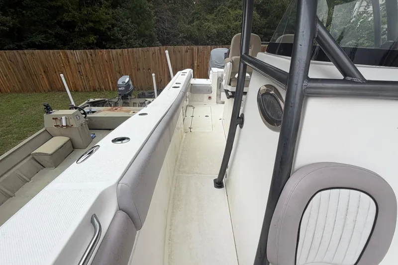 Slide: The Image of 2015 Sea Fox 286 Commander boat interior with seating and railing, parked outdoors. - 11