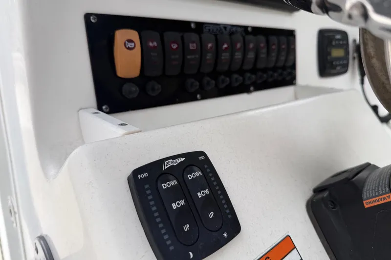 Slide: The Image of Control panel of a 2015 Sea Fox 286 Commander boat, featuring switches and trim tab controls. - 17