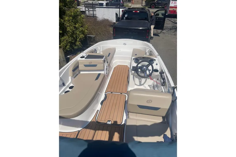 Slide: The Image of 2023 Hurricane SunDeck Sport 185 OB boat interior with beige seating and wood-style flooring. - 4