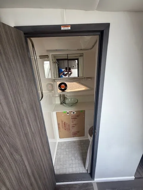 Slide: The Image of View into a modern boat cabin with a wooden door, sink, and window. - 14