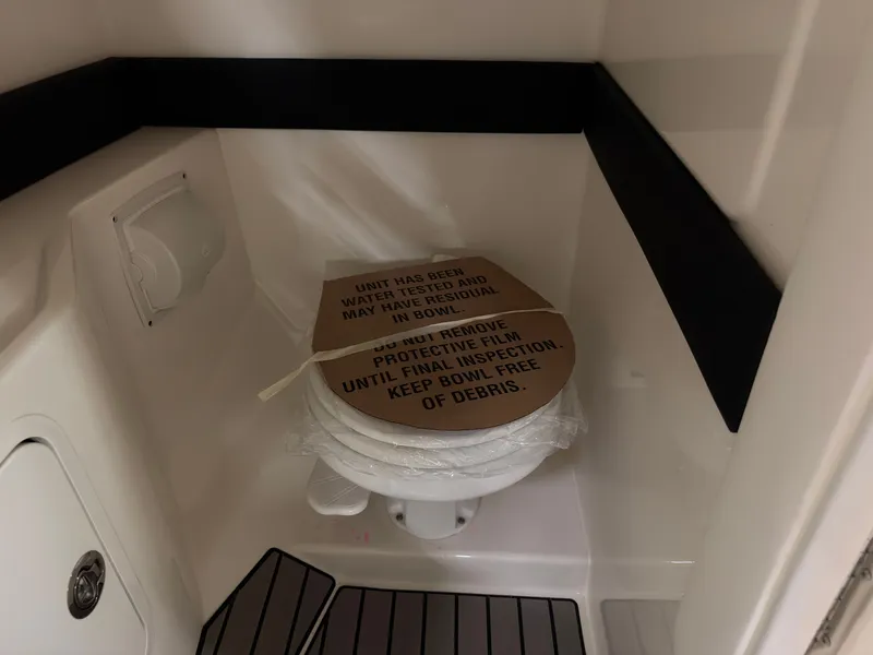 Slide: The Image of The boat's toilet with a protective cover and inspection warning. - 36