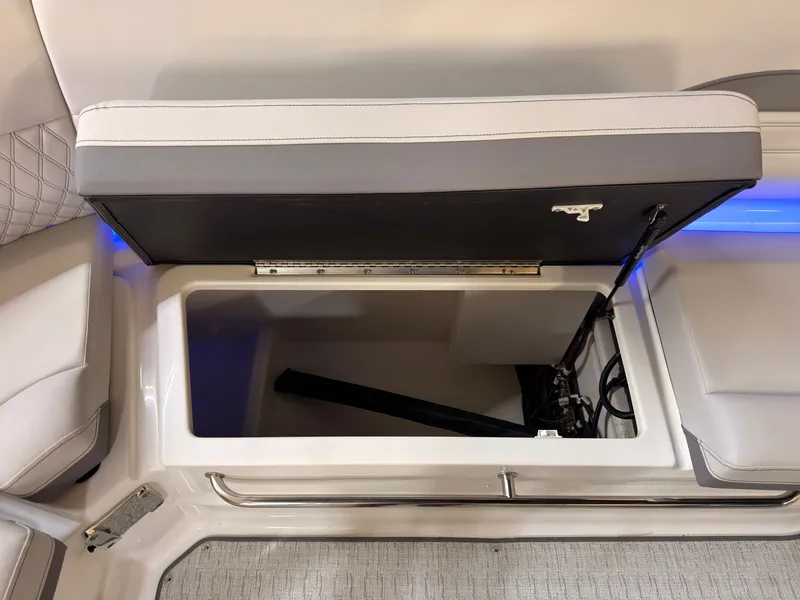 Slide: The Image of An open storage compartment on a 2026 Sea Ray SLX 280 boat with cushioned seating. - 23