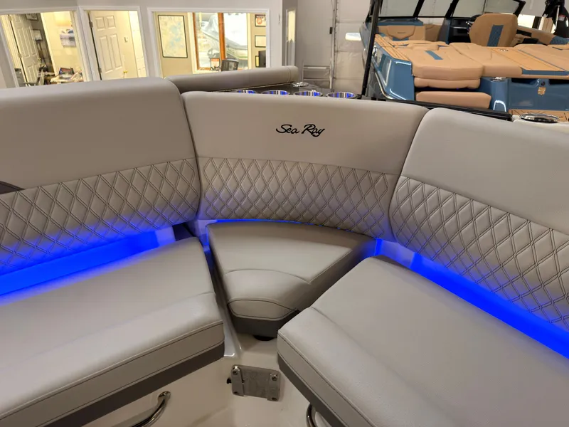 Slide: The Image of The 2026 Sea Ray SLX 280 features a luxurious, cushioned seating area with blue LED lighting. - 21