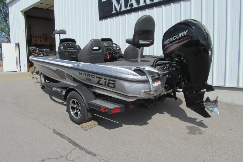 Slide: The Image of 2017 Nitro Z18 fishing boat with Mercury outboard motor, parked outside a building. - 3