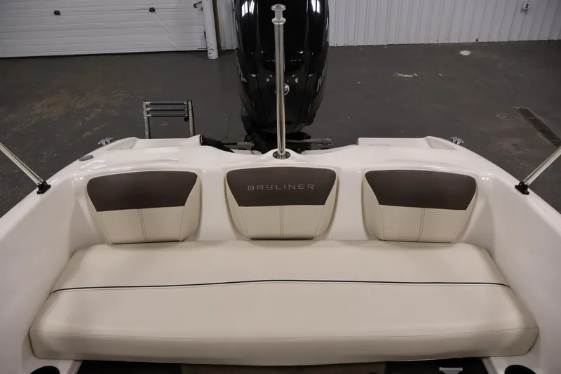 Slide: The Image of 2019 Bayliner 160 Bowrider boat interior with cushioned seating and motor view. - 23