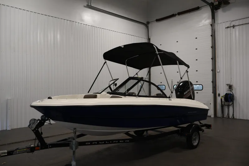 Slide: The Image of 2019 Bayliner 160 Bowrider boat with canopy in indoor storage. - 25