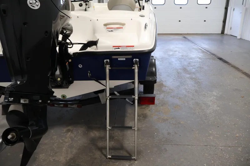 Slide: The Image of 2019 Bayliner 160 Bowrider boat with ladder and motor in a garage. - 26