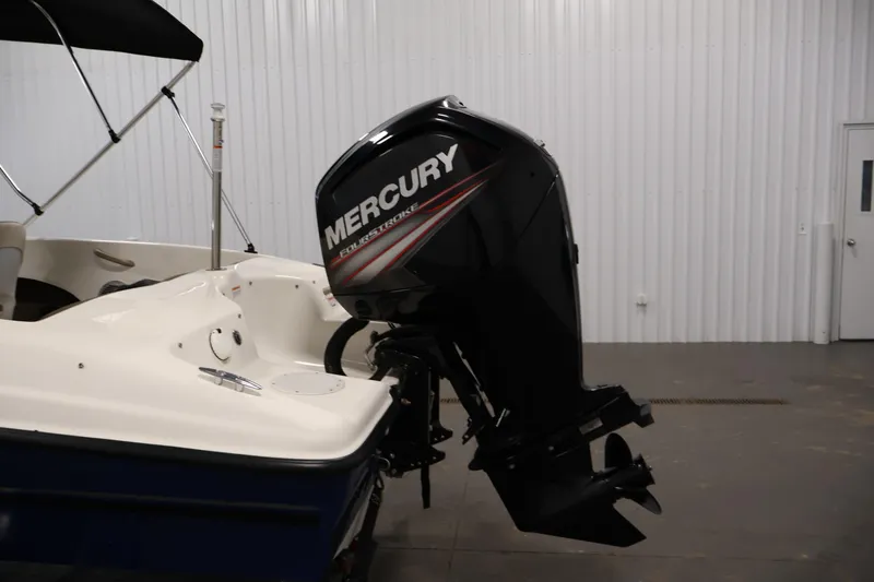 Slide: The Image of 2019 Bayliner 160 Bowrider with Mercury FourStroke outboard motor in a garage setting. - 28