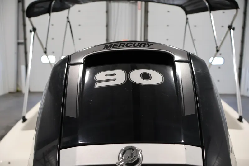 Slide: The Image of 2019 Bayliner 160 Bowrider with Mercury 90 engine in a garage setting. - 29