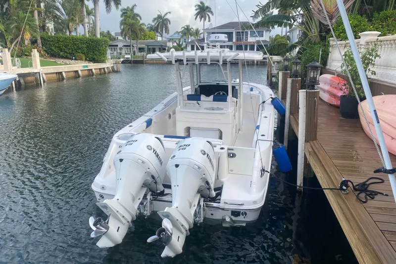 Slide: The Image of 2021 Robalo R302 Center Console boat covered on a trailer under a cloudy sky. - 30