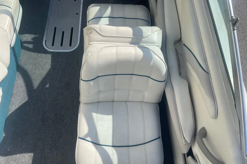 Slide: The Image of 1996 Sea Ray 210 Bow Rider interior with white cushioned seating and carpeted floor. - 11