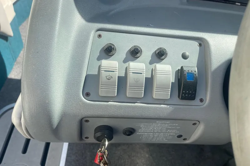 Slide: The Image of Control panel of a 1996 Sea Ray 210 Bow Rider boat with switches and key ignition. - 14