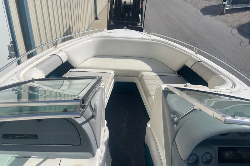 Slide: The Image of 1996 Sea Ray 210 Bow Rider boat interior with white seating and open windshield. - 19
