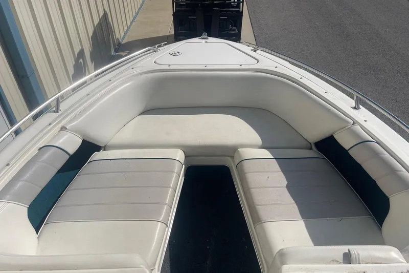 Slide: The Image of 1996 Sea Ray 210 Bow Rider boat with white cushioned seating in the bow area. - 20