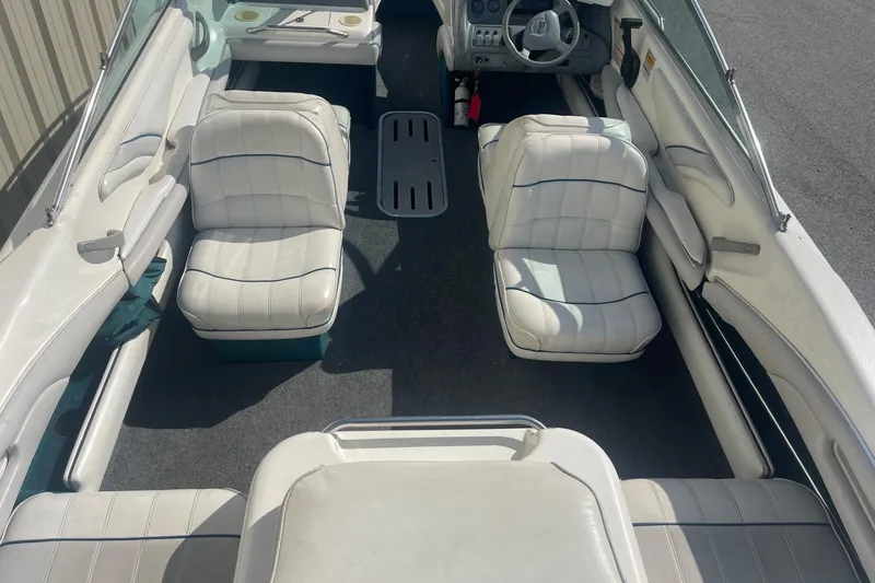 Slide: The Image of 1996 Sea Ray 210 Bow Rider interior with white seating and steering console. - 6