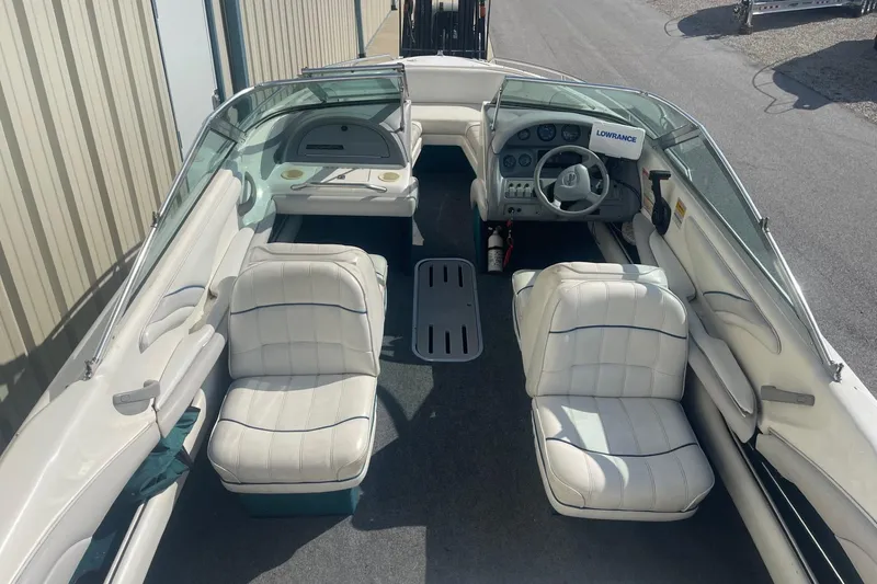 Slide: The Image of 1996 Sea Ray 210 Bow Rider interior with white seating and steering console. - 7