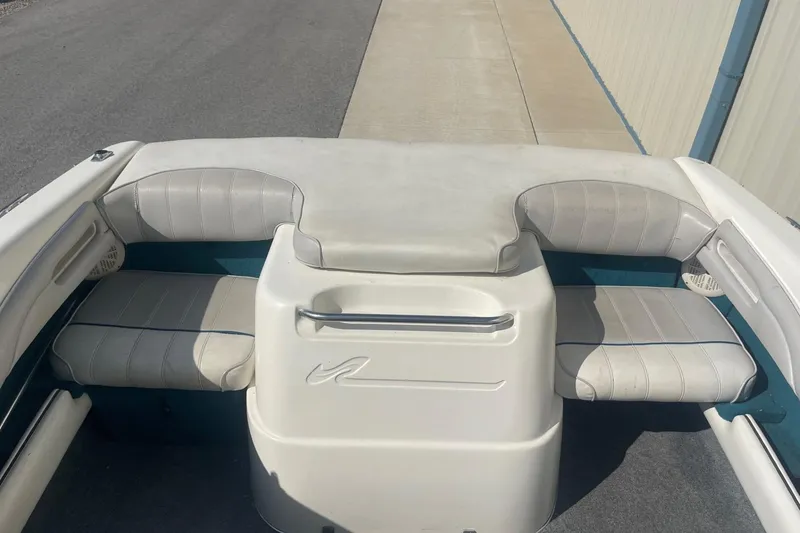 Slide: The Image of 1996 Sea Ray 210 Bow Rider interior with white cushioned seating and storage area. - 8