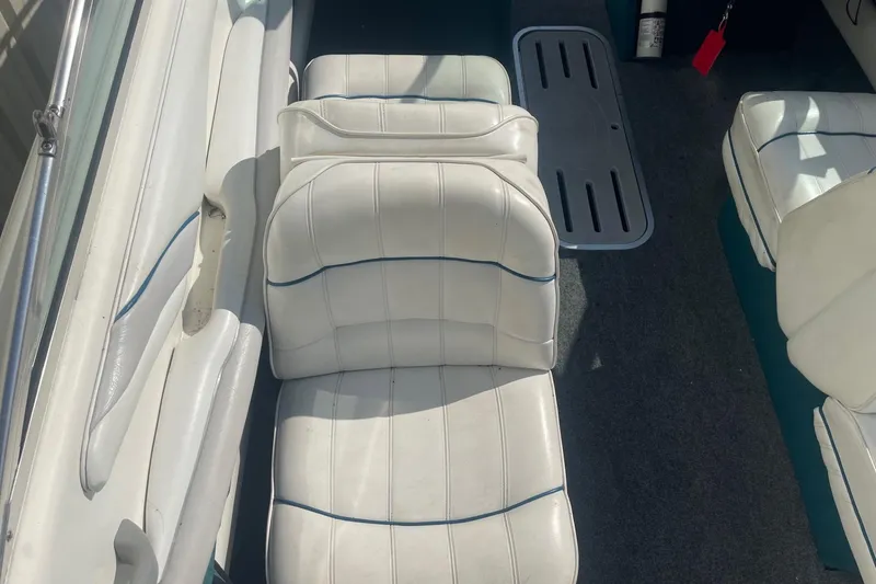 Slide: The Image of 1996 Sea Ray 210 Bow Rider interior with white cushioned seating and carpeted floor. - 9
