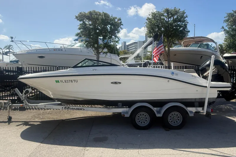 The Image of 2020 Sea Ray SPX 210 Outboard boat on trailer, parked outdoors under clear sky. - 1