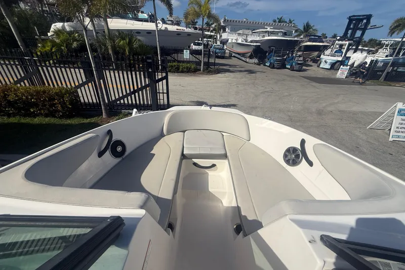 Slide: The Image of 2020 Sea Ray SPX 210 Outboard boat interior with seating, docked at a marina. - 25