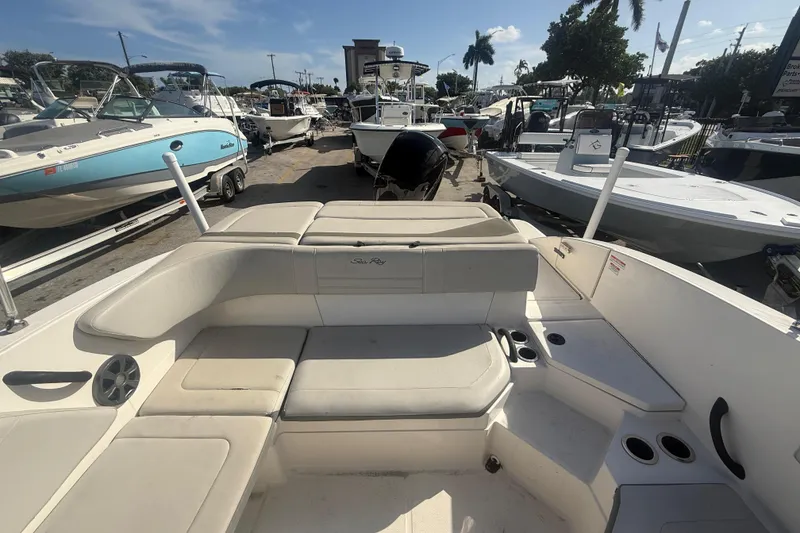 Slide: The Image of 2020 Sea Ray SPX 210 Outboard boat interior with seating and cup holders, docked among other boats. - 6