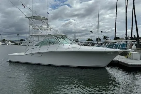 The Image of 2008 Cabo 40 Express yacht docked in a marina under cloudy skies. - 0