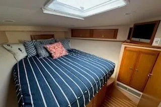 Slide: The Image of 2008 Cabo 40 Express cabin interior with striped bedding and wooden cabinetry. - 10