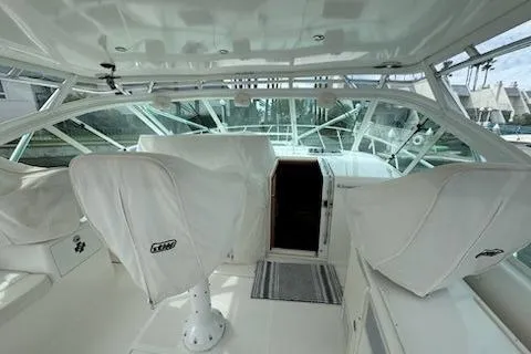 Slide: The Image of 2008 Cabo 40 Express yacht interior with covered seating and helm station. - 16