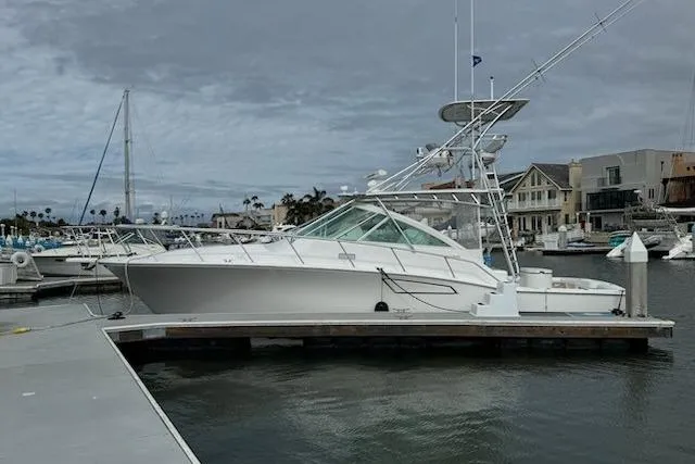 Slide: The Image of 2008 Cabo 40 Express yacht docked at a marina under cloudy skies. - 2