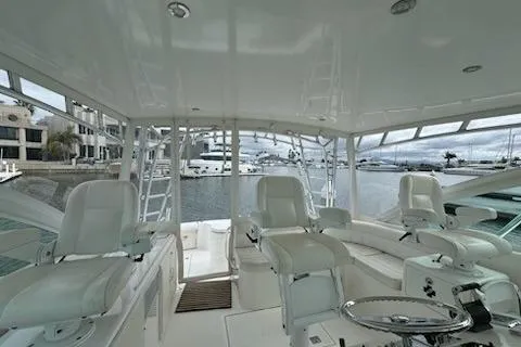 Slide: The Image of 2008 Cabo 40 Express yacht interior with white seating and marina view. - 20