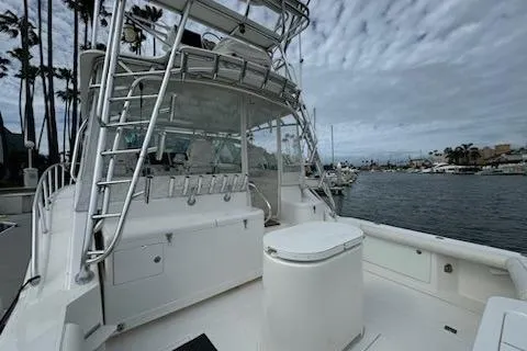 Slide: The Image of 2008 Cabo 40 Express boat with tower, docked in a marina under cloudy skies. - 22