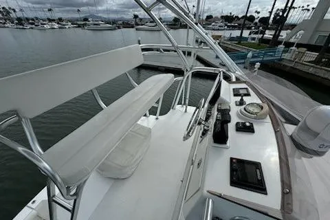 Slide: The Image of 2008 Cabo 40 Express boat helm with controls, bench seating, and marina view. - 25