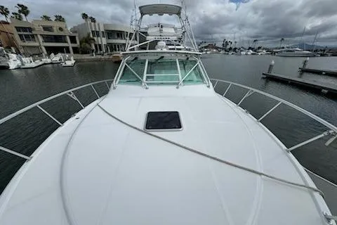 Slide: The Image of 2008 Cabo 40 Express yacht docked in a marina, showcasing sleek design and spacious deck. - 29