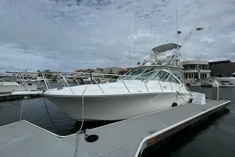 Slide: The Image of 2008 Cabo 40 Express boat docked at marina under cloudy sky. - 3