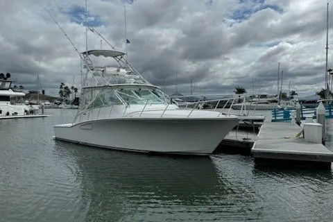 Slide: The Image of 2008 Cabo 40 Express yacht docked in a marina under cloudy skies. - 7