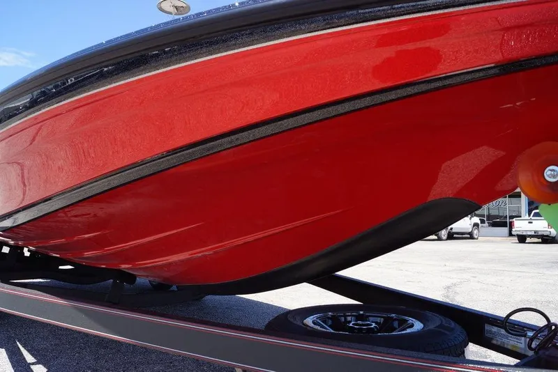 Slide: The Image of Red 2026 Skeeter ZXE21 boat hull on trailer, showcasing sleek design. - 11
