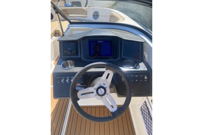 Slide: The Image of 2023 Bayliner VR5 Bowrider I/O dashboard with steering wheel and control panel. - 2