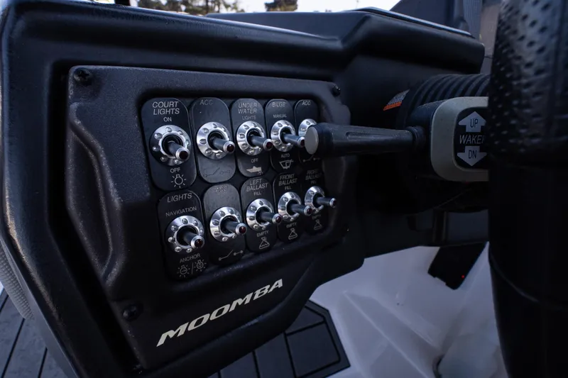 Slide: The Image of Control panel of 2022 Moomba Max boat with various switches and steering wheel. - 16