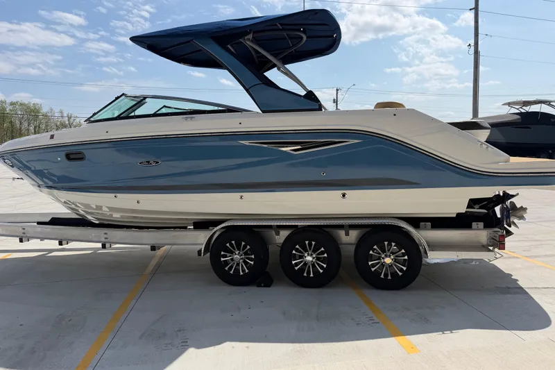 Slide: The Image of 2021 Sea Ray SLX 280 boat on trailer, parked outdoors under a clear sky. - 10