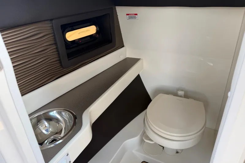 Slide: The Image of 2021 Sea Ray SLX 280 boat interior with toilet and sink. - 23