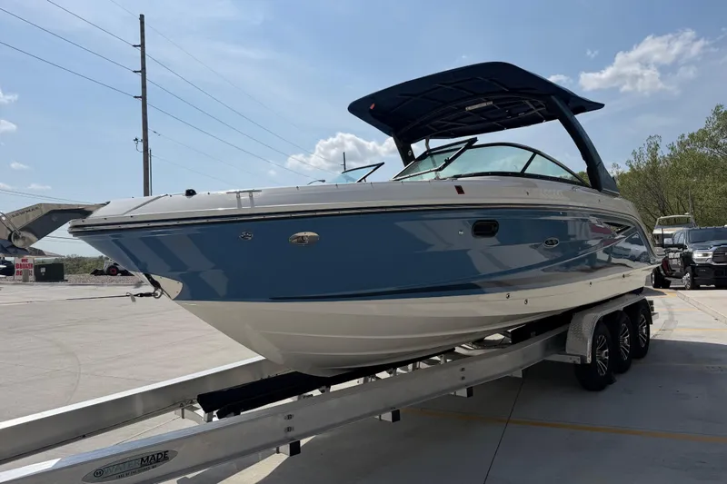 Slide: The Image of 2021 Sea Ray SLX 280 boat on trailer, blue and white design, parked outdoors. - 8