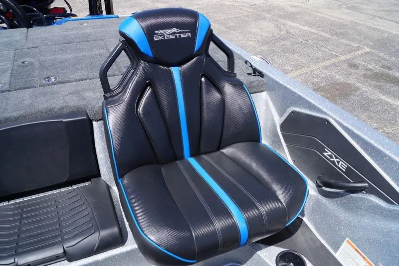 Slide: The Image of 2026 Skeeter ZXE21 boat seat with black and blue design, featuring logo and textured finish. - 15