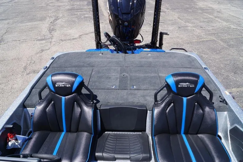 Slide: The Image of 2026 Skeeter ZXE21 boat interior with black and blue seats, rear motor visible. - 20