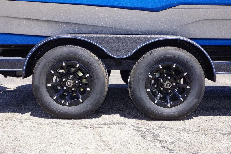 Slide: The Image of 2026 Skeeter ZXE21 trailer with dual black alloy wheels on pavement. - 3