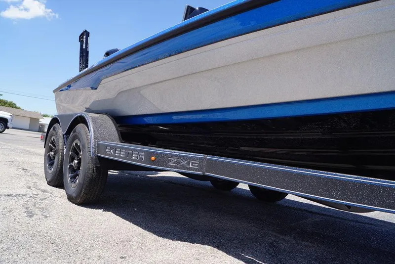 Slide: The Image of 2026 Skeeter ZXE21 boat on trailer, showcasing sleek design and dual axles. - 9