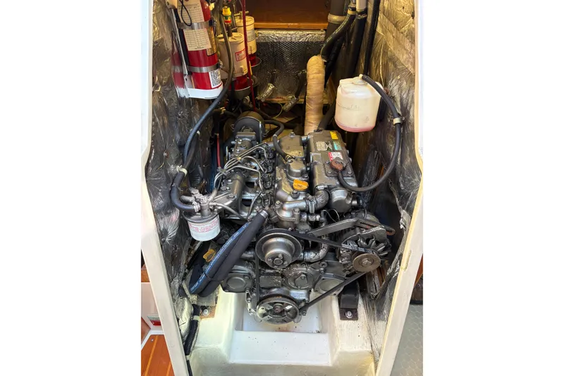 Slide: The Image of Engine compartment of a 1998 Catalina 42 MkII sailboat, featuring mechanical components and fire extinguishers. - 34
