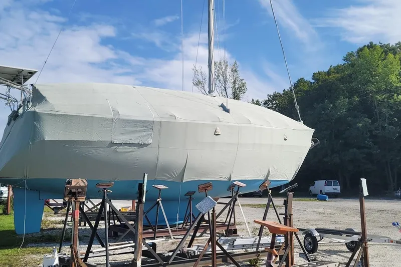 Slide: The Image of 1998 Catalina 42 MkII sailboat covered and elevated on stands in a boatyard. - 38