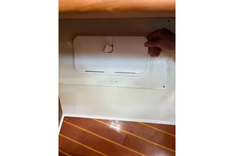 Slide: The Image of Hand opening compartment on 1998 Catalina 42 MkII sailboat with wooden flooring. - 39